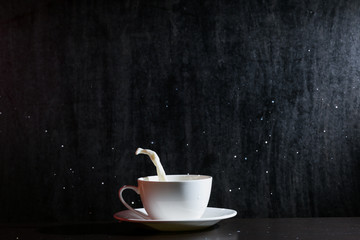 white cup of splashing milk