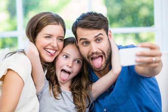 Happy family making faces while clicking selfie 