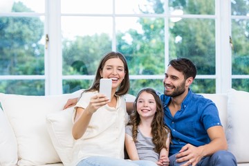 Woman looking at smart phone while sitting with family 