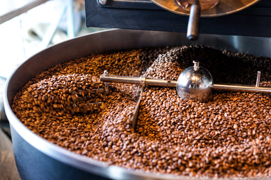 Freshly roasted coffee beans from a large roaster in the cooling cylinder. Motion blur on beans.