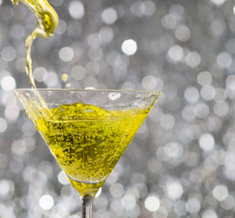 alcoholic cocktail over silver sparkling background