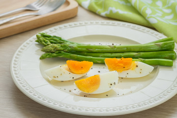 Boiled egg with asparagus on plate