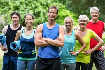 Fitness class posing with sports mats