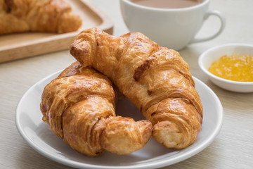 Croissant on plate and coffee cup