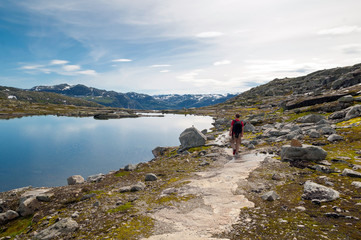 Fototapeta na wymiar man walking on a mountain trail in Norway. Path to Trolltunga