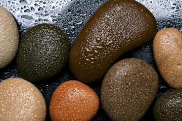 Fototapeta na wymiar Wet colored stones background, dark pebbles. 