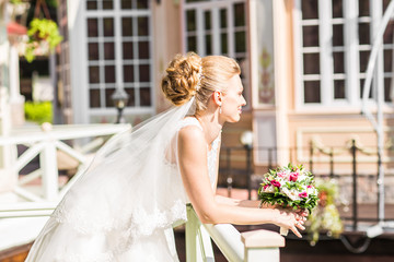 Beautiful bride with bouquet of flowers outdoor