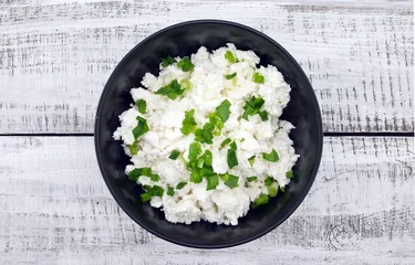 Cercles muraux Produits laitiers Cottage cheese with chives in black ceramic bowl 