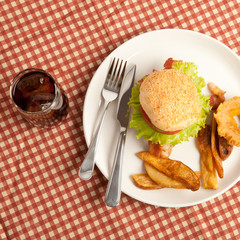 Hamburger and fried with glass of coke or pepsi on picnic trip top view
