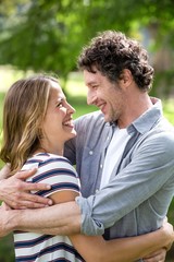 Smiling couple embracing in park