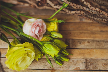 eustoma and rose  lying on a wooden board