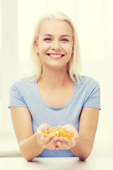 happy woman holding fish oil capsules at home