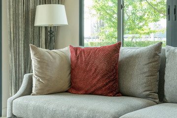 modern living room with red pillows on gray sofa and decorative lamp