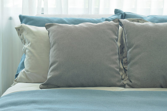 Gray Pillows Setting On Blue Color Scheme Bedding