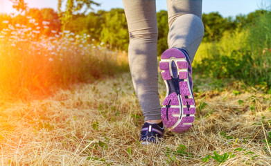 Woman running at sunset in a field