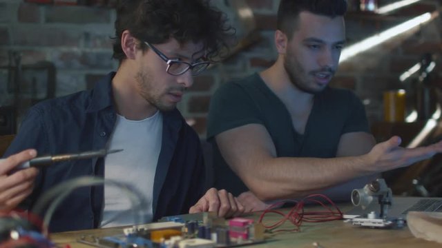 Two students are studying electronics and soldering in a garage. Shot on RED Cinema Camera.