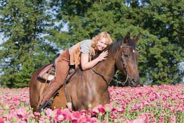Attractive woman posing on horse in the poppy field