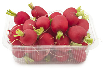 Box or punnet of raw organic small garden radishes isolated on white background