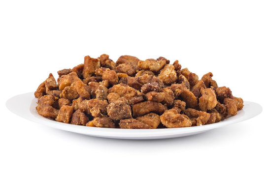 Heap of domestic salty fried pork greaves, cvarci, on plate isolated on white