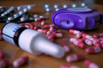 Plastic allergy inhaler used to reduce allergic and asthma reaction in blue and violet color with nasal spray, pills and capsules 