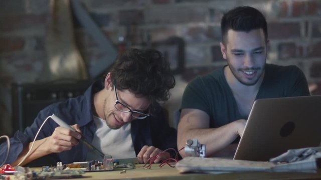 Two students are studying electronics and soldering in a garage. Shot on RED Cinema Camera.