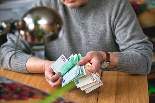 an elderly man counts money, Euro