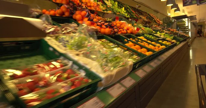 Shopping cart in supermarket among fruit and vegetable. Shopping cart point of view