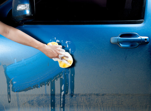 Man Washing A Soapy Blue Car With A Sponge.