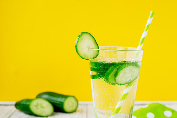
detox , healthy and refreshing drink ,Nutritious cold sparkling water with fresh green cucumber on a wooden background