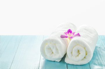 Fototapeta na wymiar White towels roll with purple orchid flower