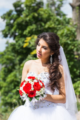 Young bride in wedding dress holding bouquet