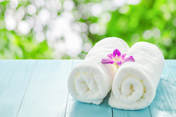 White towels roll with purple orchid flower