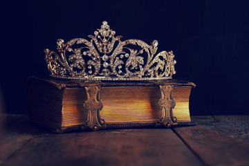 low key image of beautiful diamond queen crown on old book © tomertu