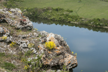 Covered with moss rocks on lake waters background