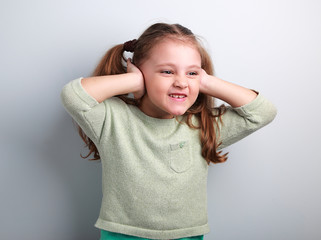 Cute fun kid girl coverd ears the fingers and gesturing that not