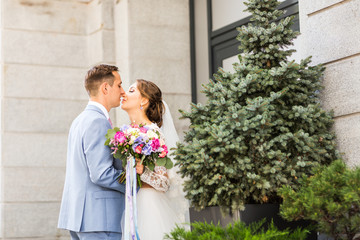 Handsome brunette groom kissing beautiful bride in wedding dress 