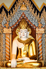 White Buddha with golden crown and robe between color columns