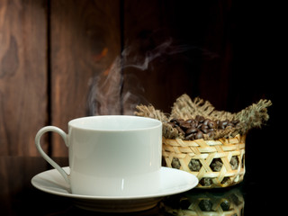 Yellow coffee cup and coffee beans on old wooden background.