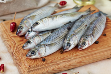 Seafood - fresh  fish  mullet with spices  on the catching board.