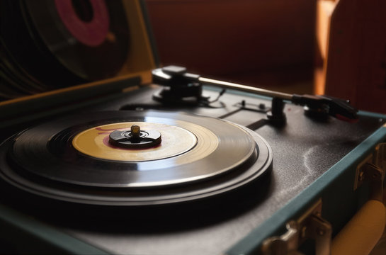 45 record vinyl disc on a vintage portable turntable.