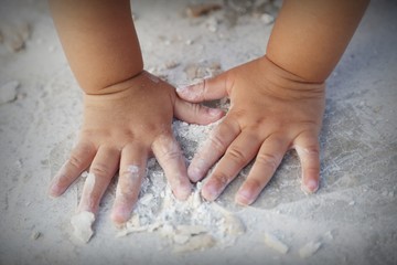 baby's hand playing on the ground