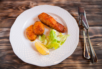 Grilled Salmon with potatoes, slice of lemon on wooden backgroun