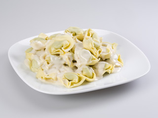 Closeup of a bowl of tortellini stuffed with spinach, four cheese sauce