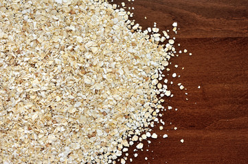 Close-up of oat flakeson dark wooden table as background or text