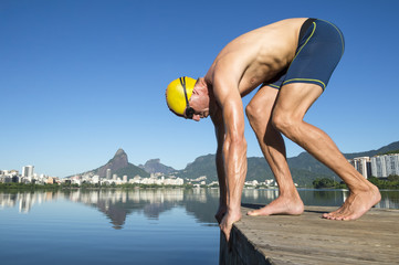 Athlete swimmer with gold swimming cap crouching in the start position for a race at the Lagoa...