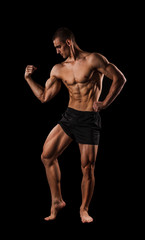 Sexy Athletic Man showing six pack abs. Isolated on black background with copy space