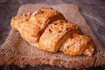 Fresh baked croissant with seeds and on burlap