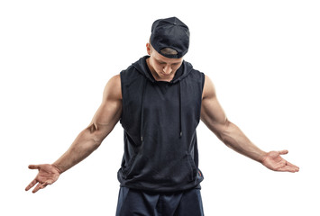 Cutout fitness man in cap wearing sleeveless shirt stands with his head down gesticulating