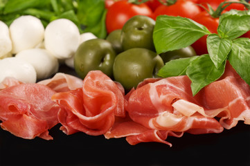 Italian appetizer: prosciutto, mozzarella, cherry tomatoes, lett