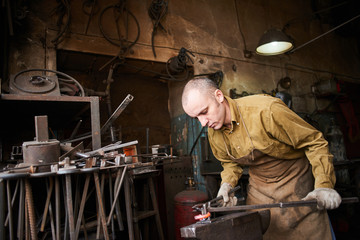 The wizard removes the excess weld using a power saw with a metal layout of a construction crane